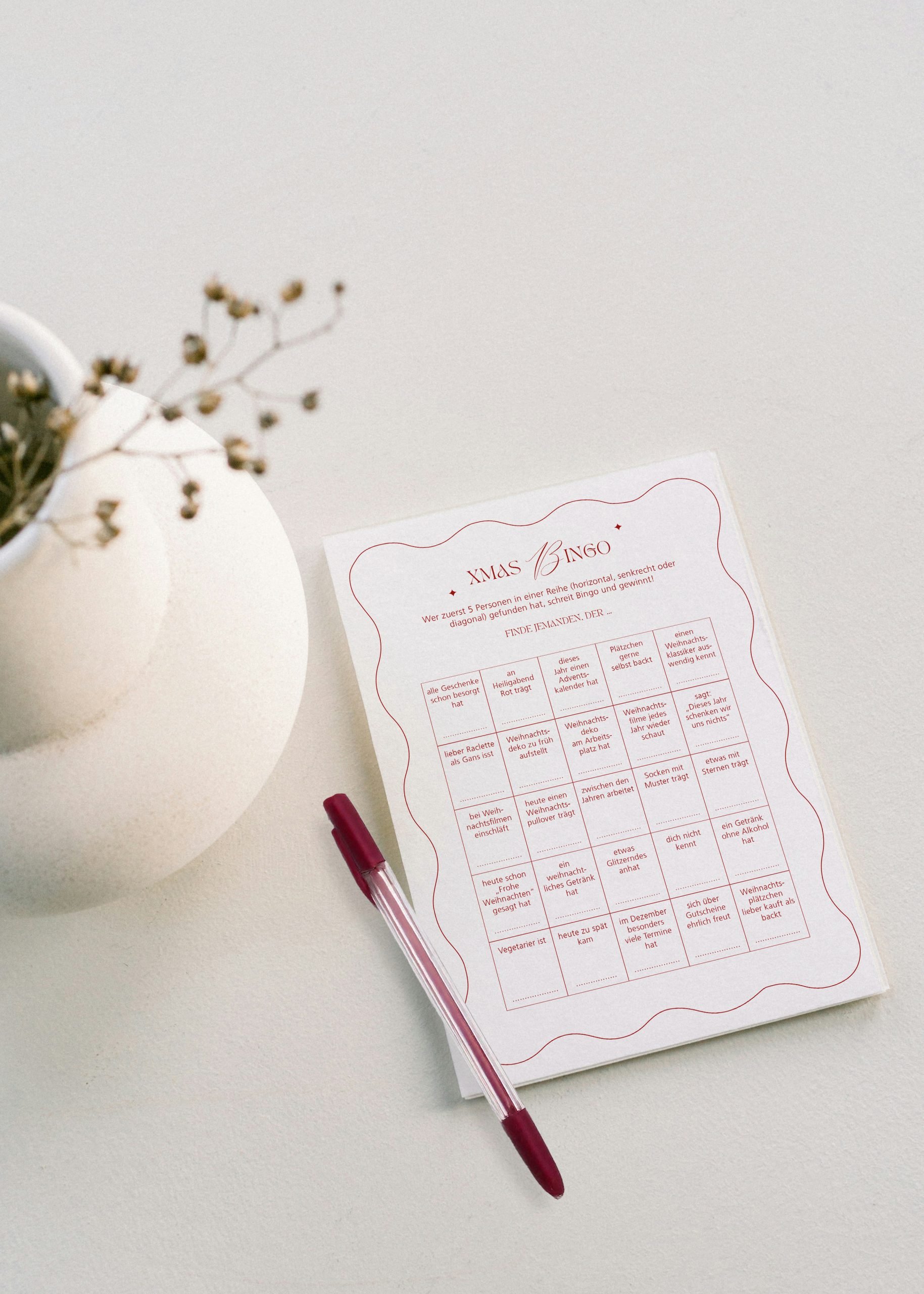 Ein Mockup zu einer Karte mit einem Weihnachtsbingo und einem Stift.