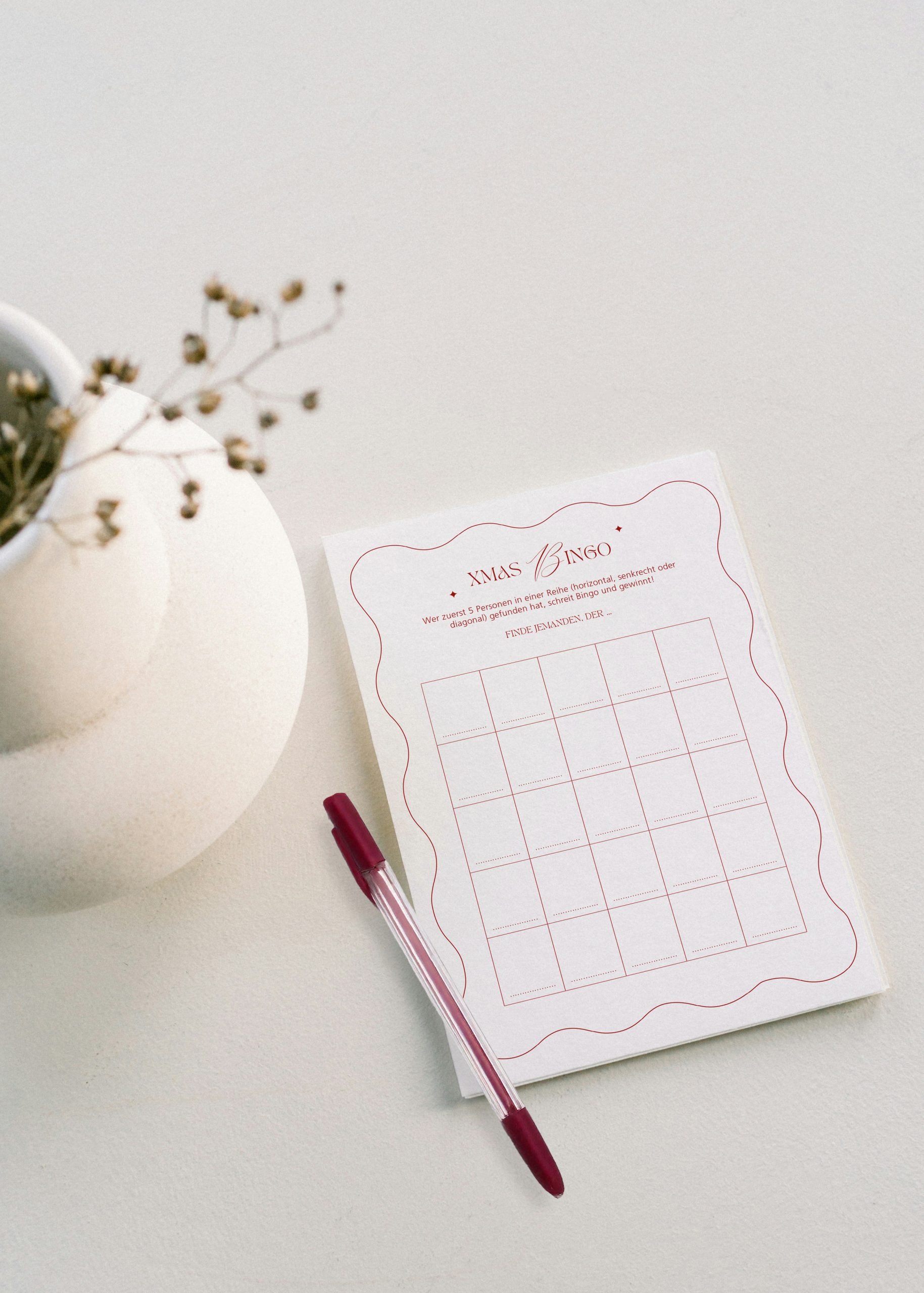 Ein Mockup zu einer Karte mit einem Weihnachtsbingo und einem Stift.